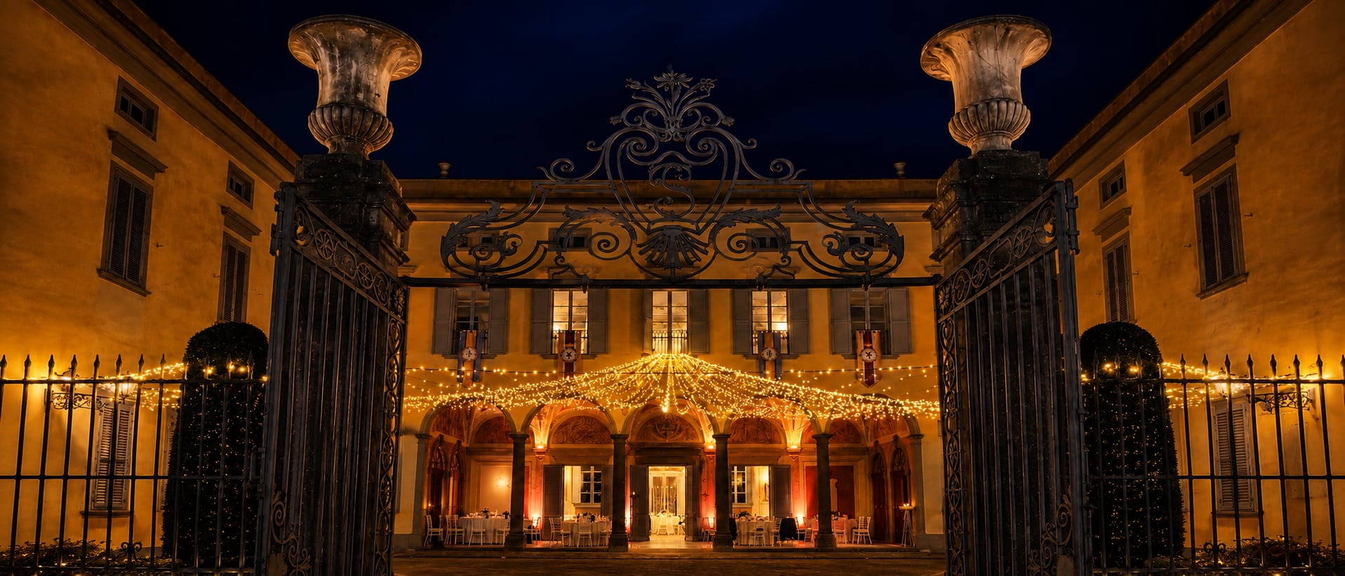 Il cancello aperto sulla villa illuminata, di sera
