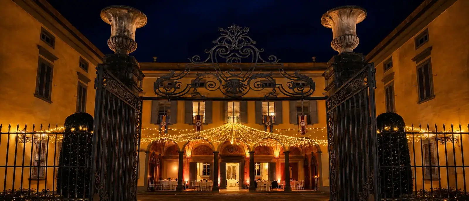 Il cancello aperto sulla villa illuminata, di sera